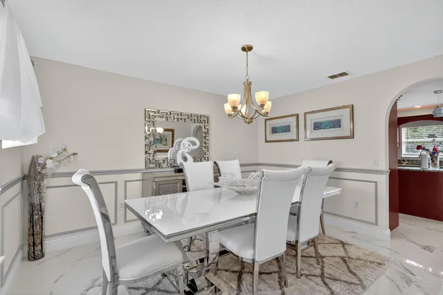 a view of a dining room with furniture and chandelier