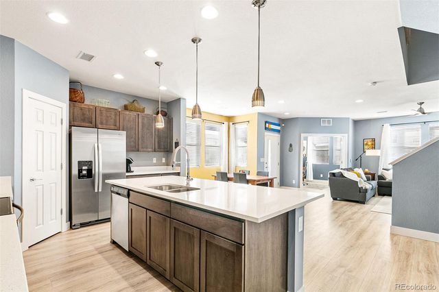 a large kitchen with kitchen island a large counter top space a sink stainless steel appliances and cabinets