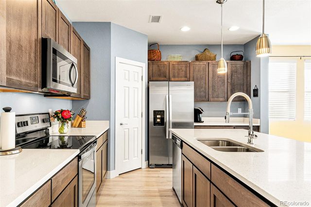 a kitchen that has a sink cabinets counter space and stainless steel appliances