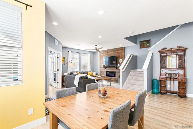 a dining room with wooden floor and large windows