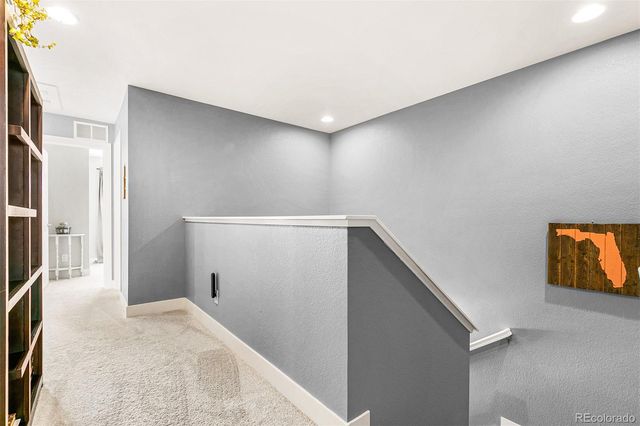a view of hallway with stairs and wooden floor