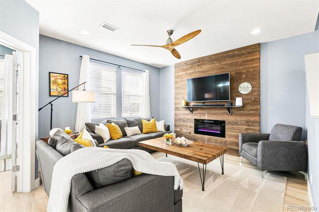 a living room with furniture a flat screen tv and a fireplace
