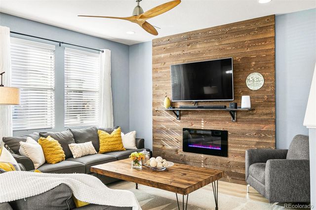 a living room with furniture a flat screen tv and a fireplace