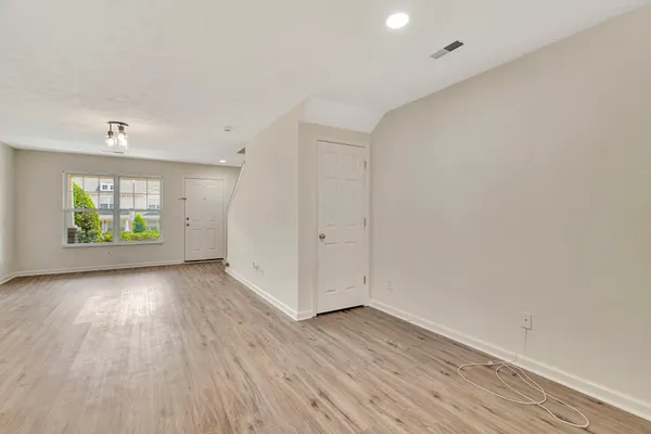 an empty room with wooden floor and windows