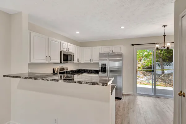 a kitchen with stainless steel appliances granite countertop a stove a sink and a refrigerator