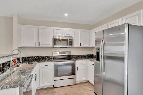 a kitchen with white cabinets and stainless steel appliances
