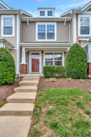a front view of a house with a yard and plants