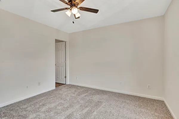 an empty room with a chandelier fan