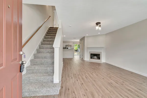 a view of a livingroom with wooden floor and a fireplace