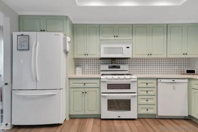 a kitchen with a refrigerator stove and white cabinets
