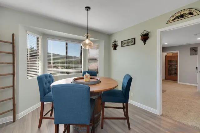 a dining room with furniture a chandelier and wooden floor