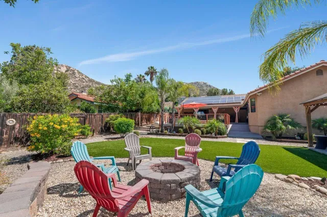 a view of a chairs and table in the back yard of the house
