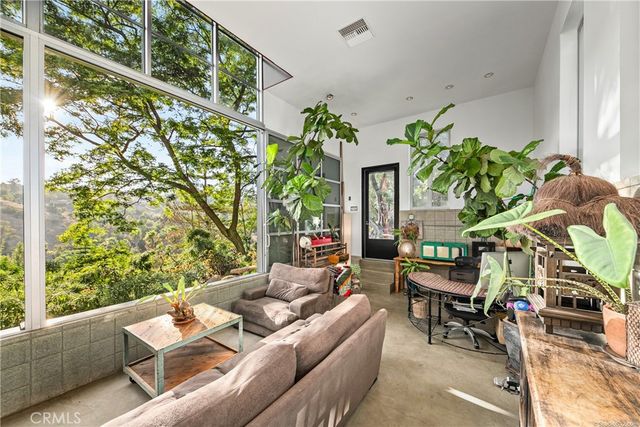a living room with furniture a flat screen tv and a floor to ceiling window