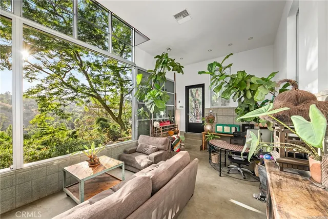 a living room with furniture a flat screen tv and a floor to ceiling window