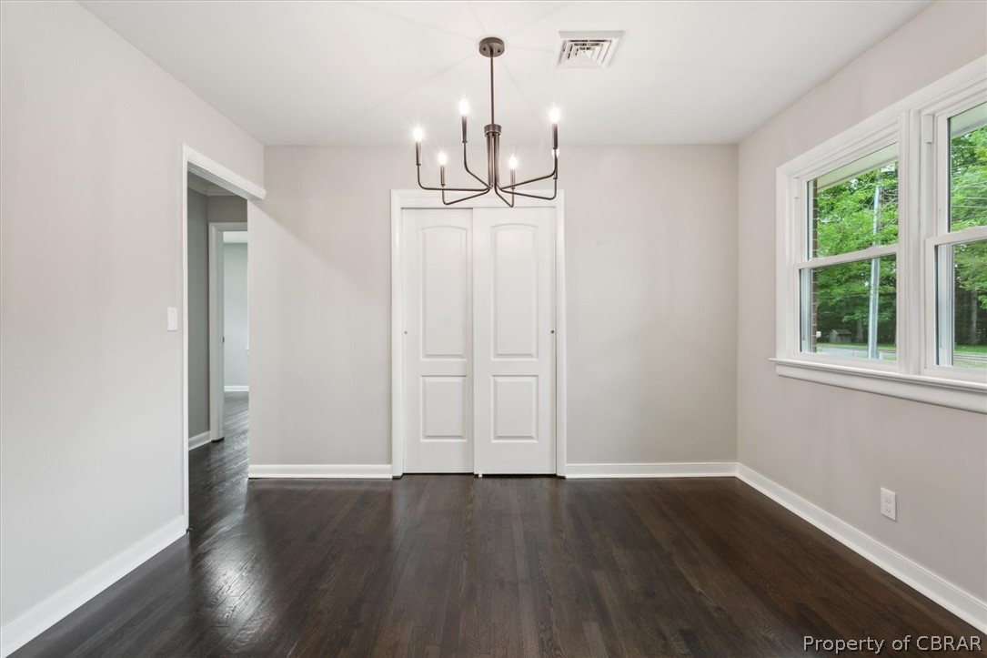 9040 Diascund Road Lanexa, VA 23089 - Photo 11 of 37 Unfurnished dining area with dark wood-type flooring and a notable chandelier