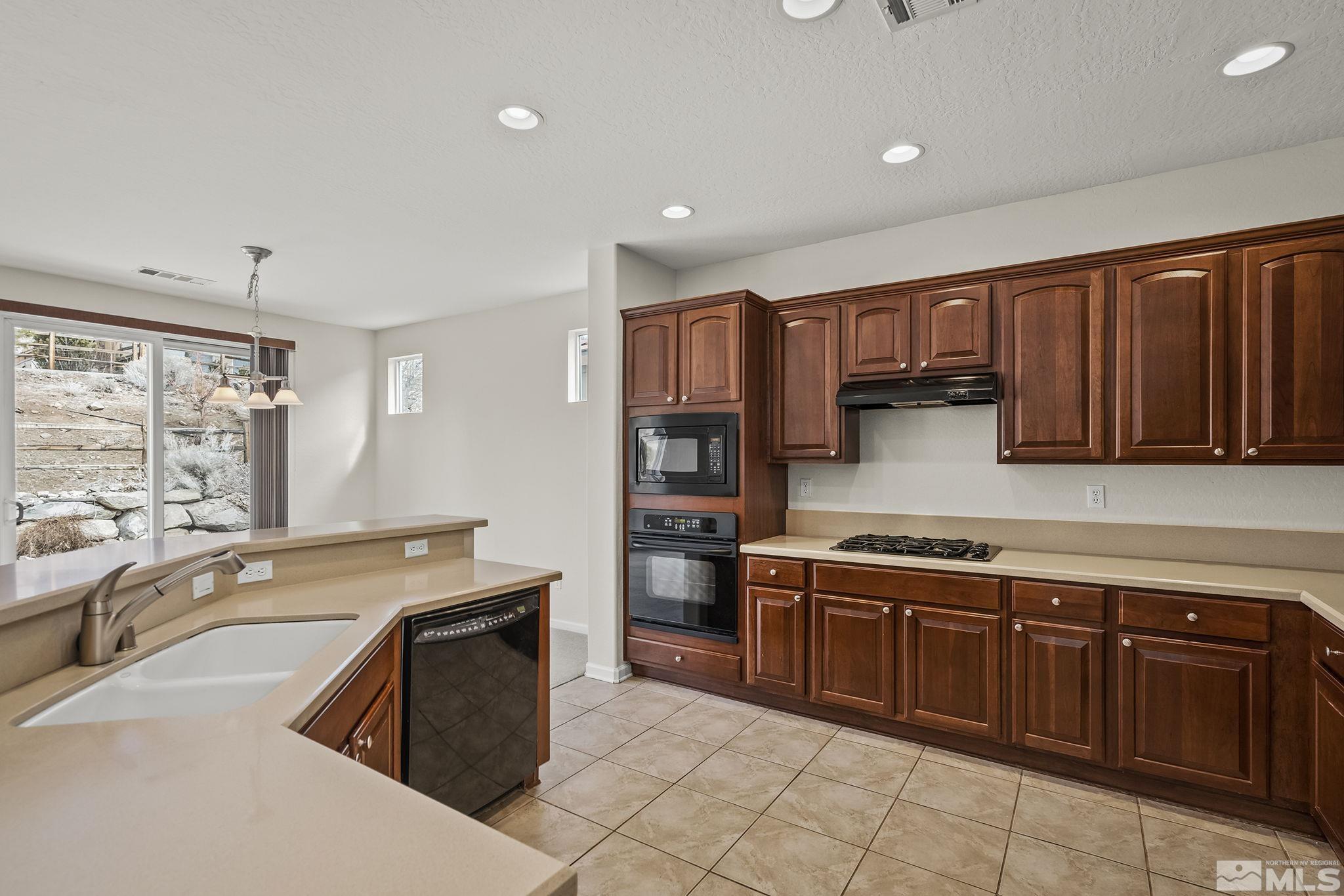 9185 Heritage Ridge Court Reno, NV 89523 - Photo 11 of 31 a kitchen with stainless steel appliances granite countertop a stove sink and cabinets