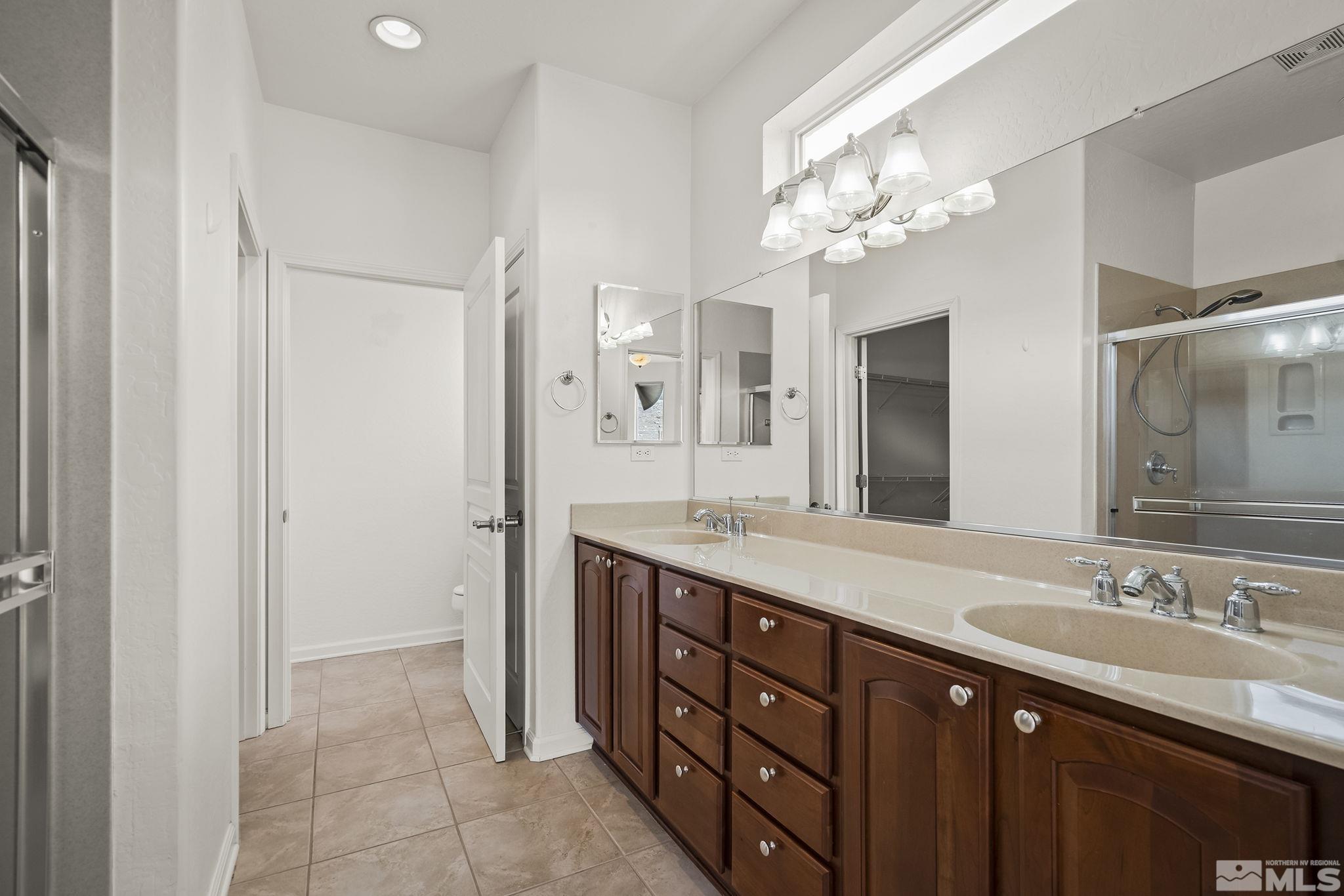 9185 Heritage Ridge Court Reno, NV 89523 - Photo 13 of 31 a spacious bathroom with a granite countertop double vanity sink a mirror and a shower