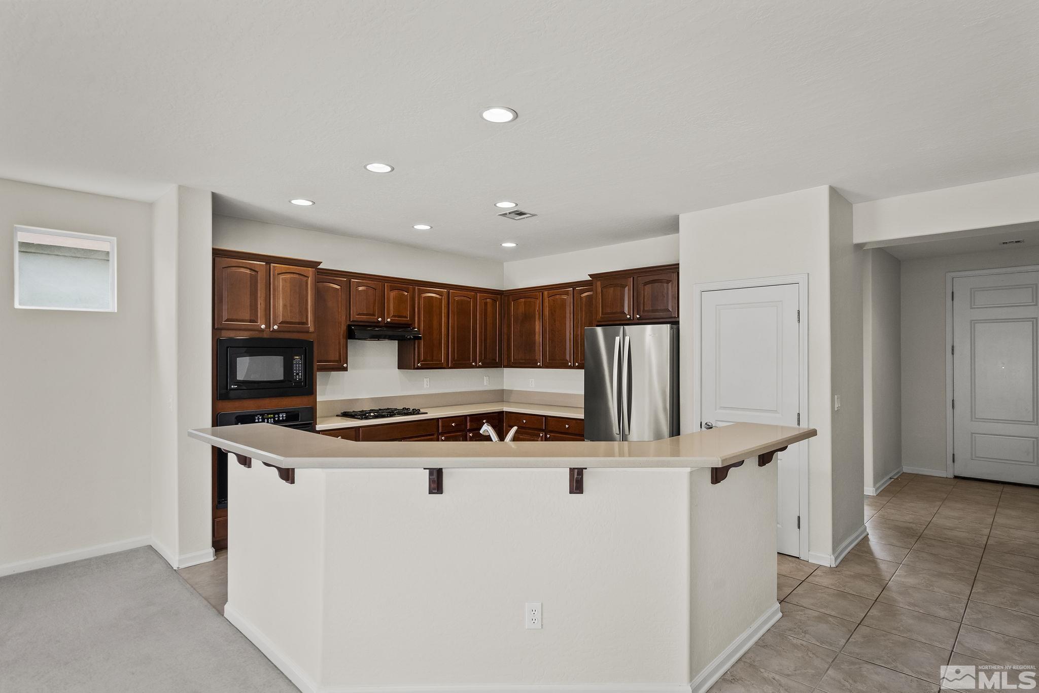 9185 Heritage Ridge Court Reno, NV 89523 - Photo 8 of 31 a kitchen with stainless steel appliances granite countertop a stove and a refrigerator