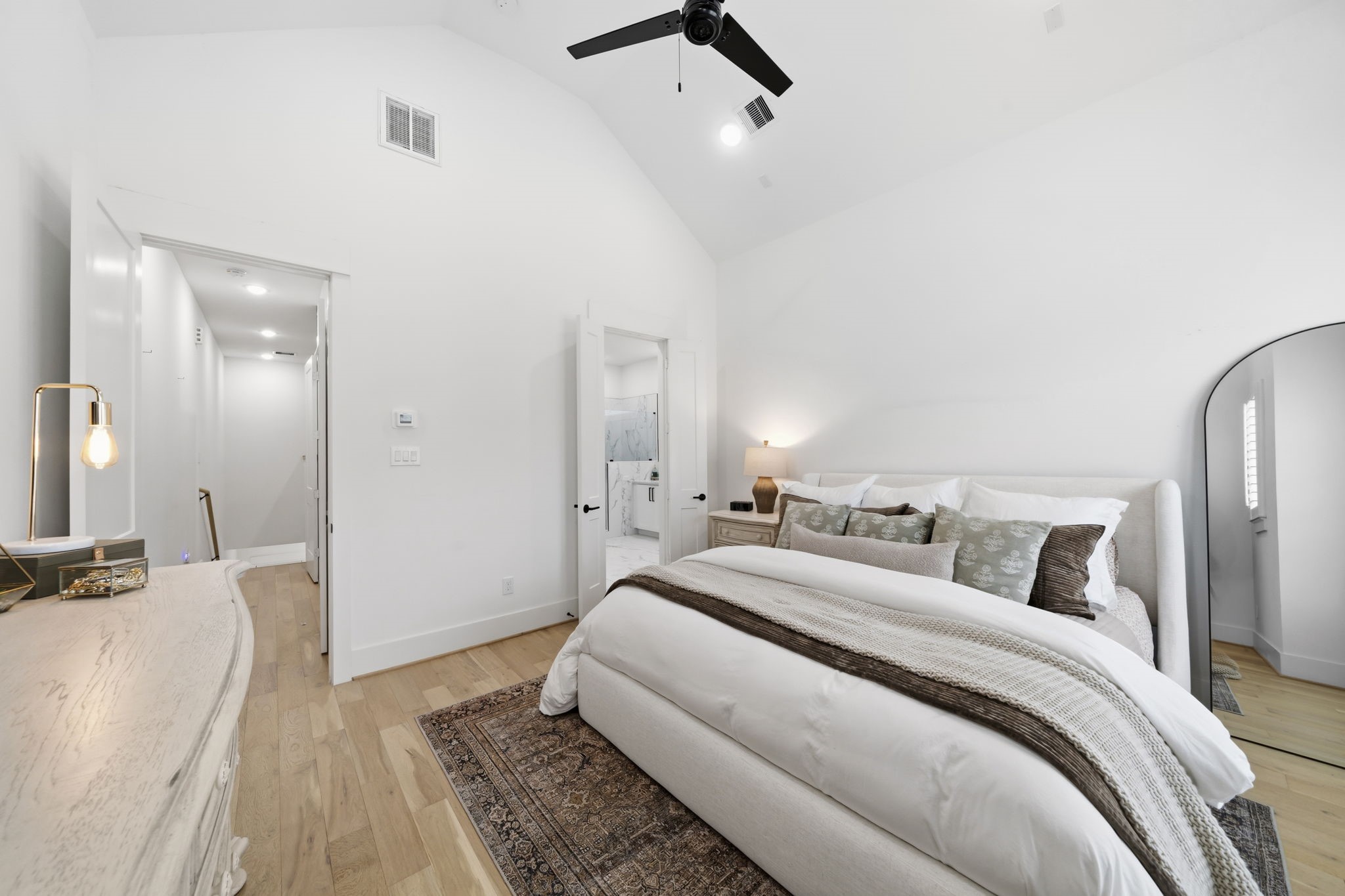 9018 Wellspring Drive Houston, TX 77080 - Photo 11 of 25 This reverse angle showcases the suite's generous proportions and high ceilings, highlighting the direct access to the luxurious en-suite bathroom and the continued designer flooring.