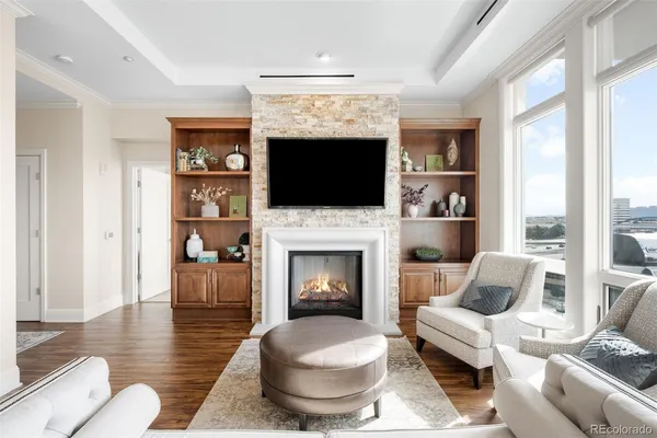 a living room with furniture a flat screen tv and a fireplace
