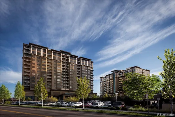 a front view of a building with lot of plants and trees