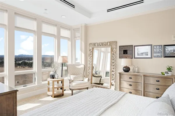 a bedroom with a bed and large windows