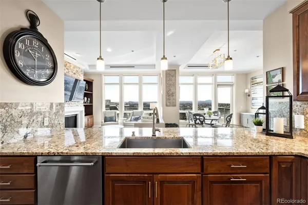 a kitchen with stainless steel appliances granite countertop a sink a stove and a wooden floors