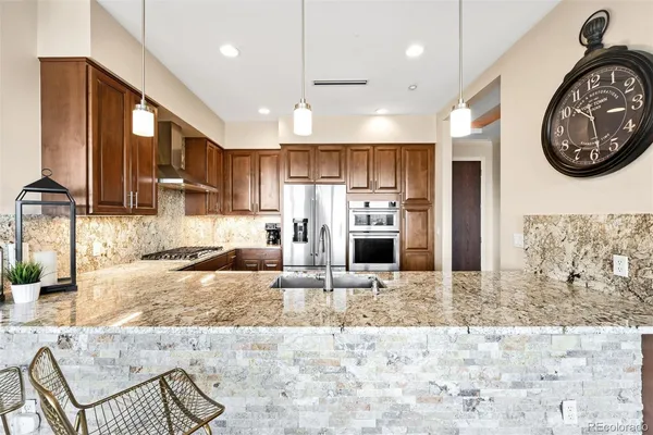 a large kitchen with stainless steel appliances kitchen island granite countertop a sink and a stove