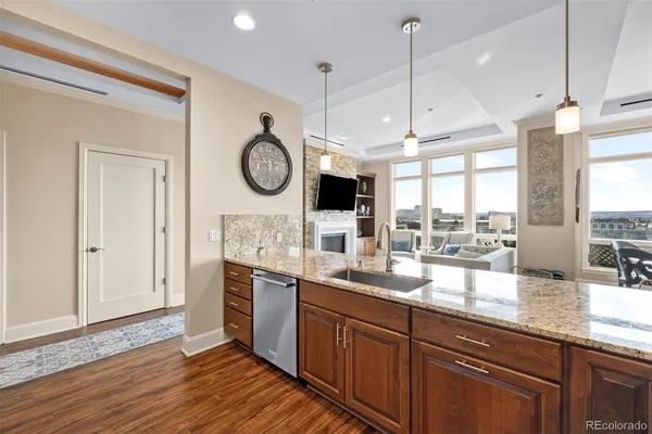 a large kitchen with granite countertop a stove a sink and a wooden floors