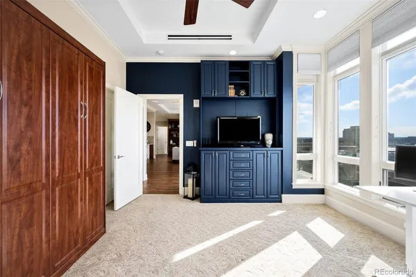 a living room with a flat screen tv and a refrigerator