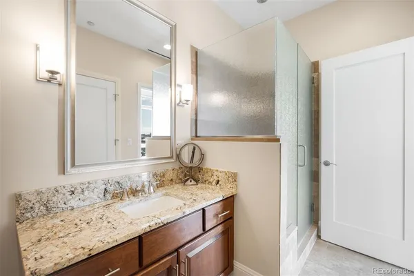a bathroom with a granite countertop sink and a mirror