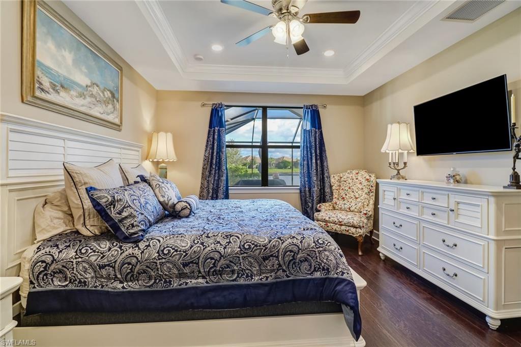 7567 Winding Cypress Drive Naples, FL 34114 - Photo 11 of 24 a bedroom with a large bed and a flat screen tv
