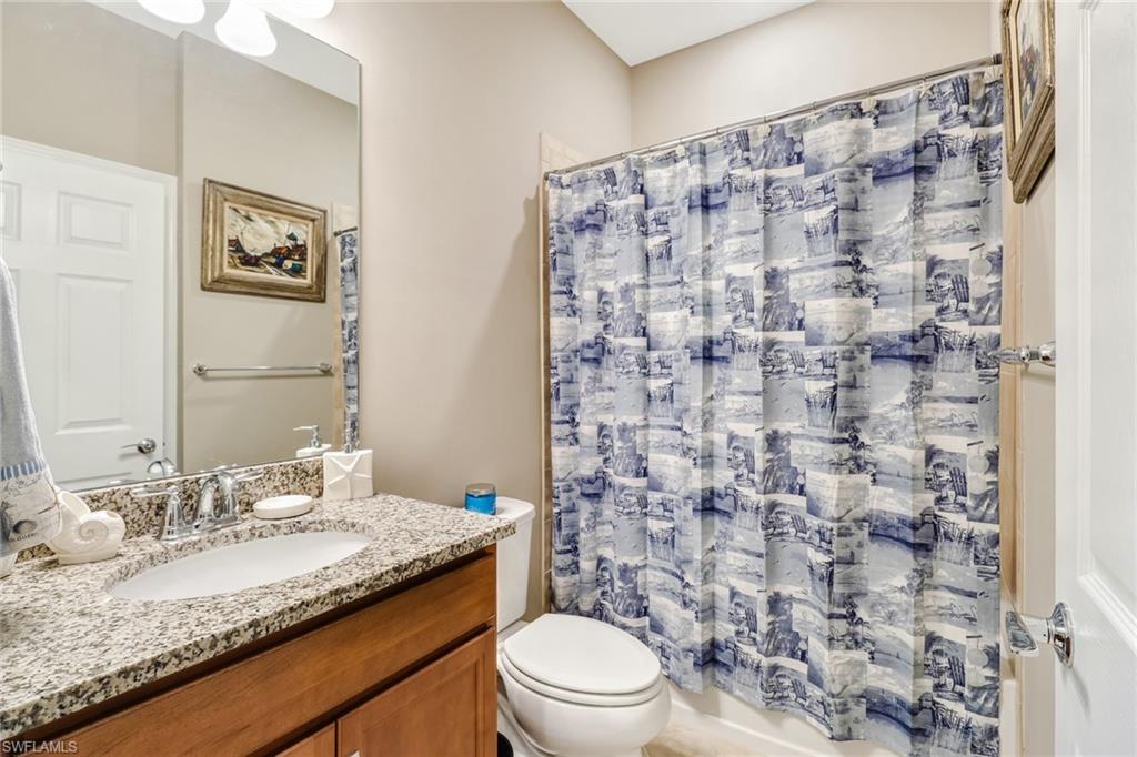 7567 Winding Cypress Drive Naples, FL 34114 - Photo 15 of 24 a bathroom with a granite countertop sink a toilet and a mirror