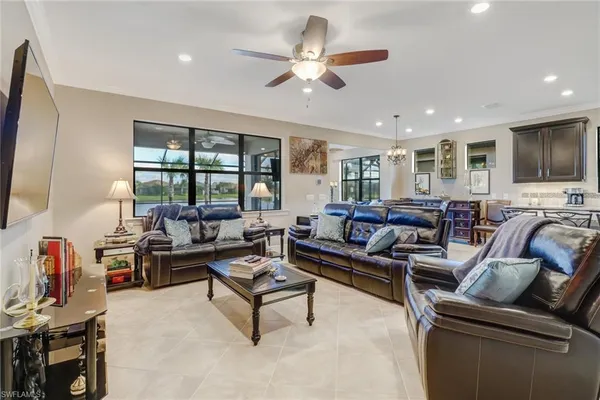 a living room with furniture ceiling fan and a flat screen tv