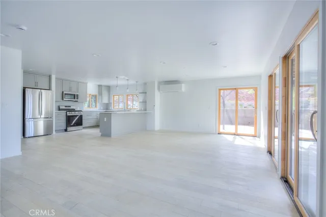 a view of a kitchen with refrigerator and windows