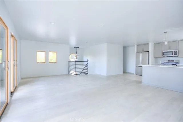 a view of empty room with wooden floor and window