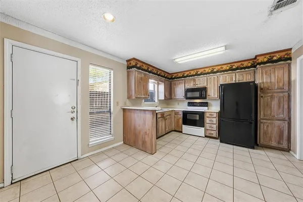 a kitchen with a refrigerator a stove top oven and cabinets