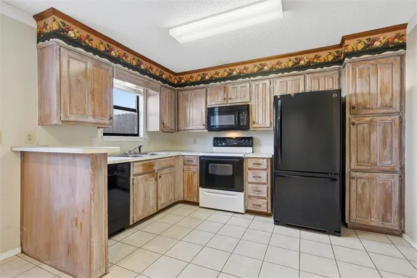 a kitchen with granite countertop white cabinets stainless steel appliances and a sink