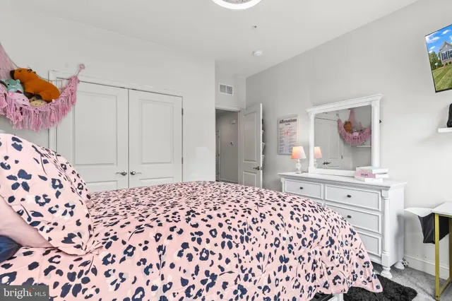 a bedroom with a bed and a dresser next to a window