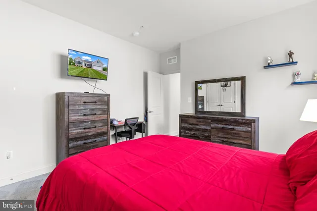 a bed sitting in a bedroom next to a window with a dresser