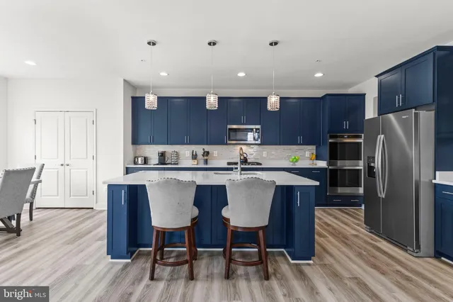 a kitchen with stainless steel appliances granite countertop a refrigerator and a sink