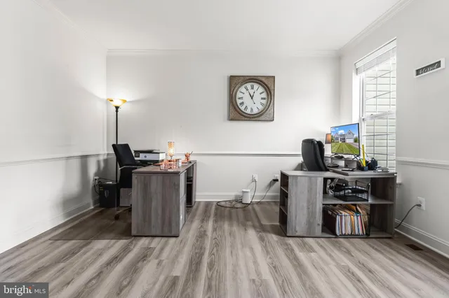 a view of a workspace with furniture and wooden floor