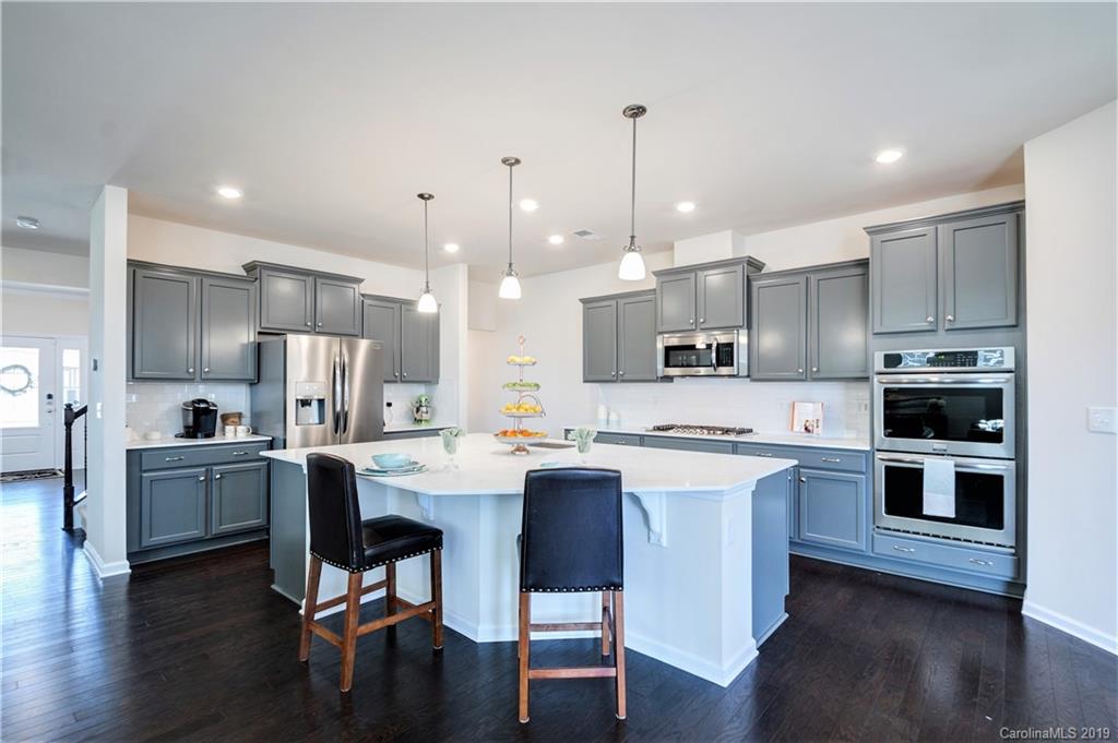 1014 Bannister Road Waxhaw, NC 28173 - Photo 11 of 48 a kitchen with cabinets a sink stainless steel appliances and wooden floor