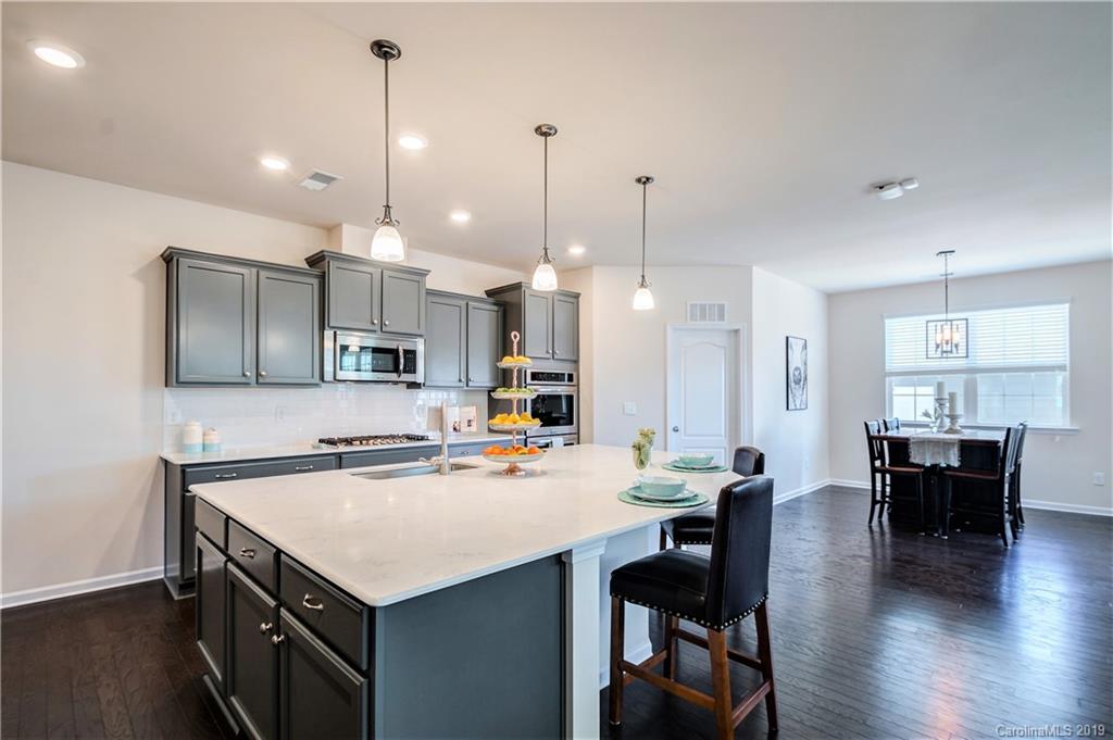 1014 Bannister Road Waxhaw, NC 28173 - Photo 15 of 48 a kitchen with kitchen island a sink table and chairs