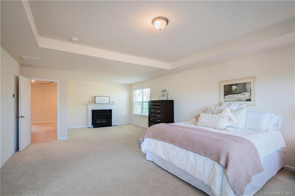 1014 Bannister Road Waxhaw, NC 28173 - Photo 24 of 48 a spacious bedroom with a bed and a fireplace