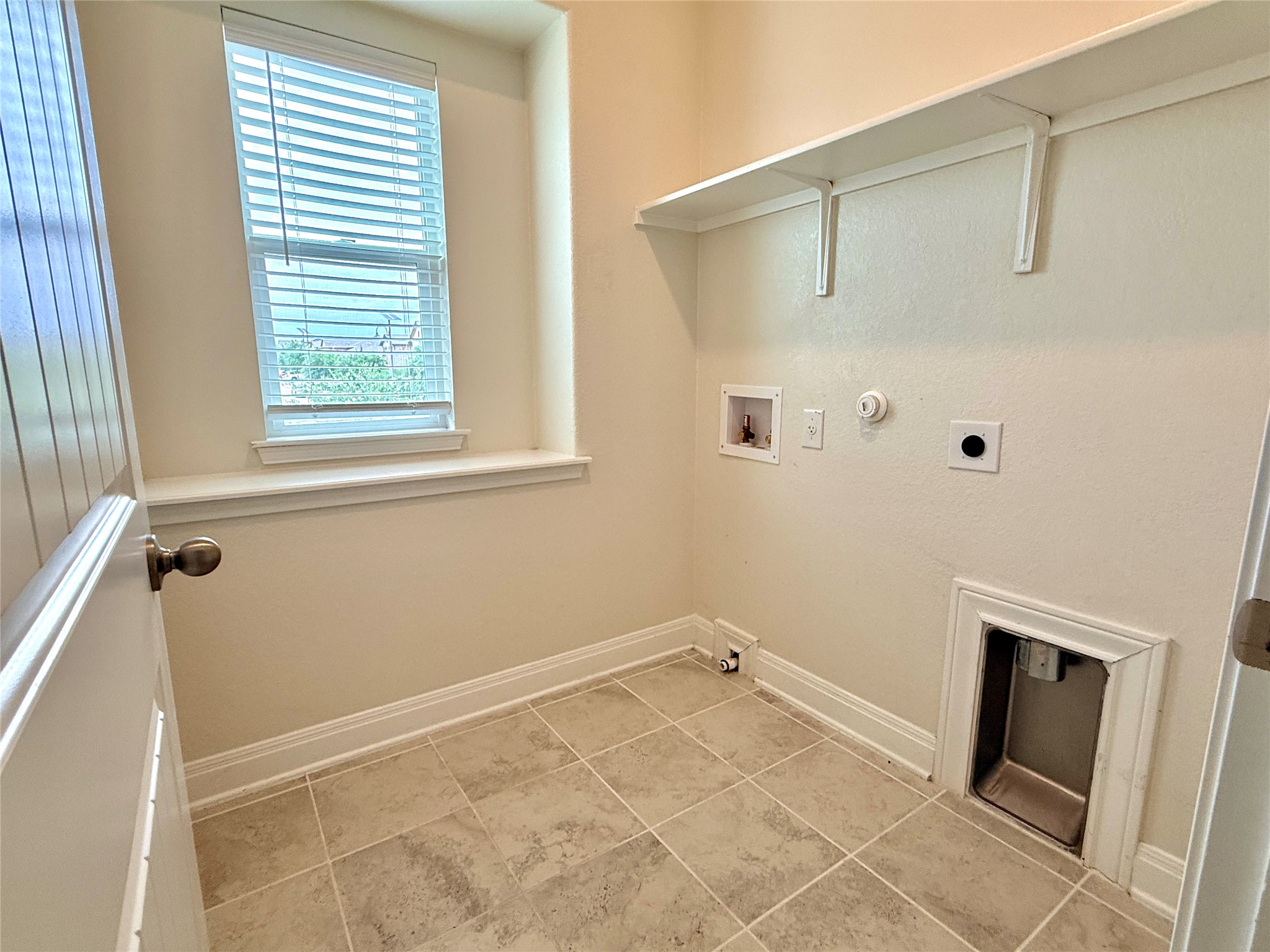 2101 Split Diamond Way, Unit 40 Round Rock, TX 78664 - Photo 28 of 32 A well-lit utility room features a large window and convenient overhead shelving.