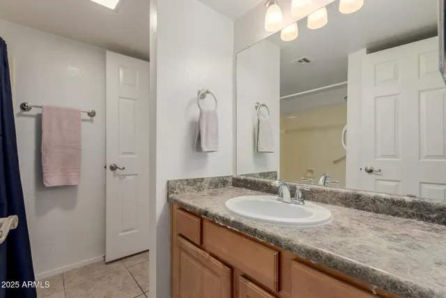 a bathroom with a granite countertop sink and a mirror