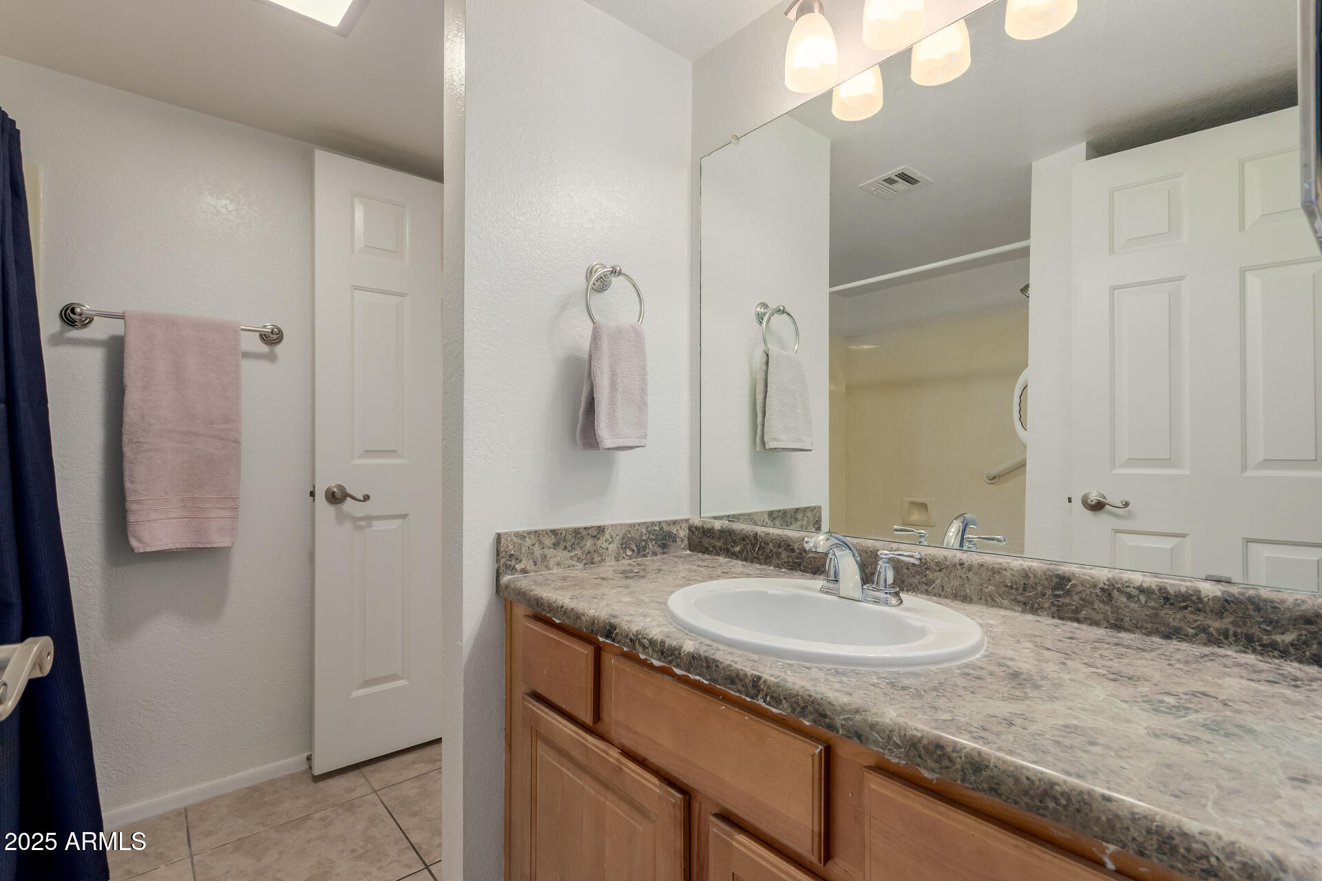 1340 North Recker Road, Unit 133 Mesa, AZ 85205 - Photo 11 of 17 a bathroom with a granite countertop sink and a mirror