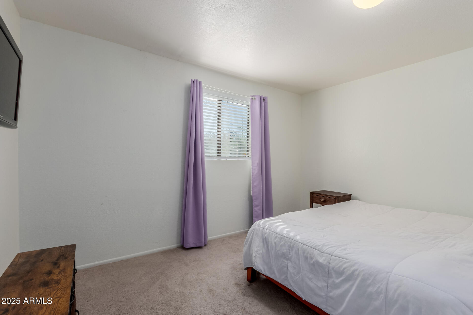 1340 North Recker Road, Unit 133 Mesa, AZ 85205 - Photo 8 of 17 a bed sitting in a bedroom next to a window