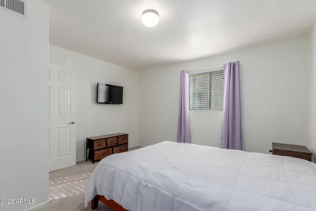 a bedroom with a bed and a flat screen tv